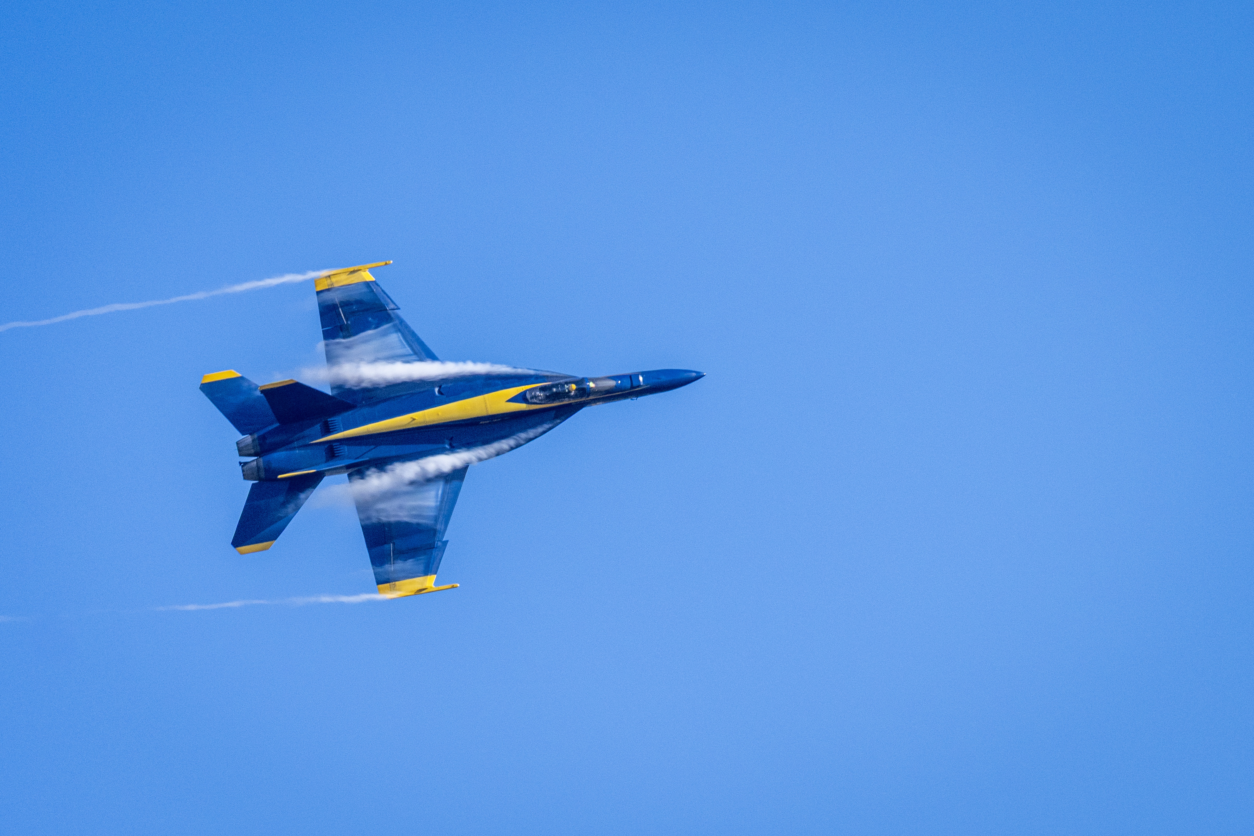 Blue Angels jet No. 5 passes overhead, showing its underside markings.