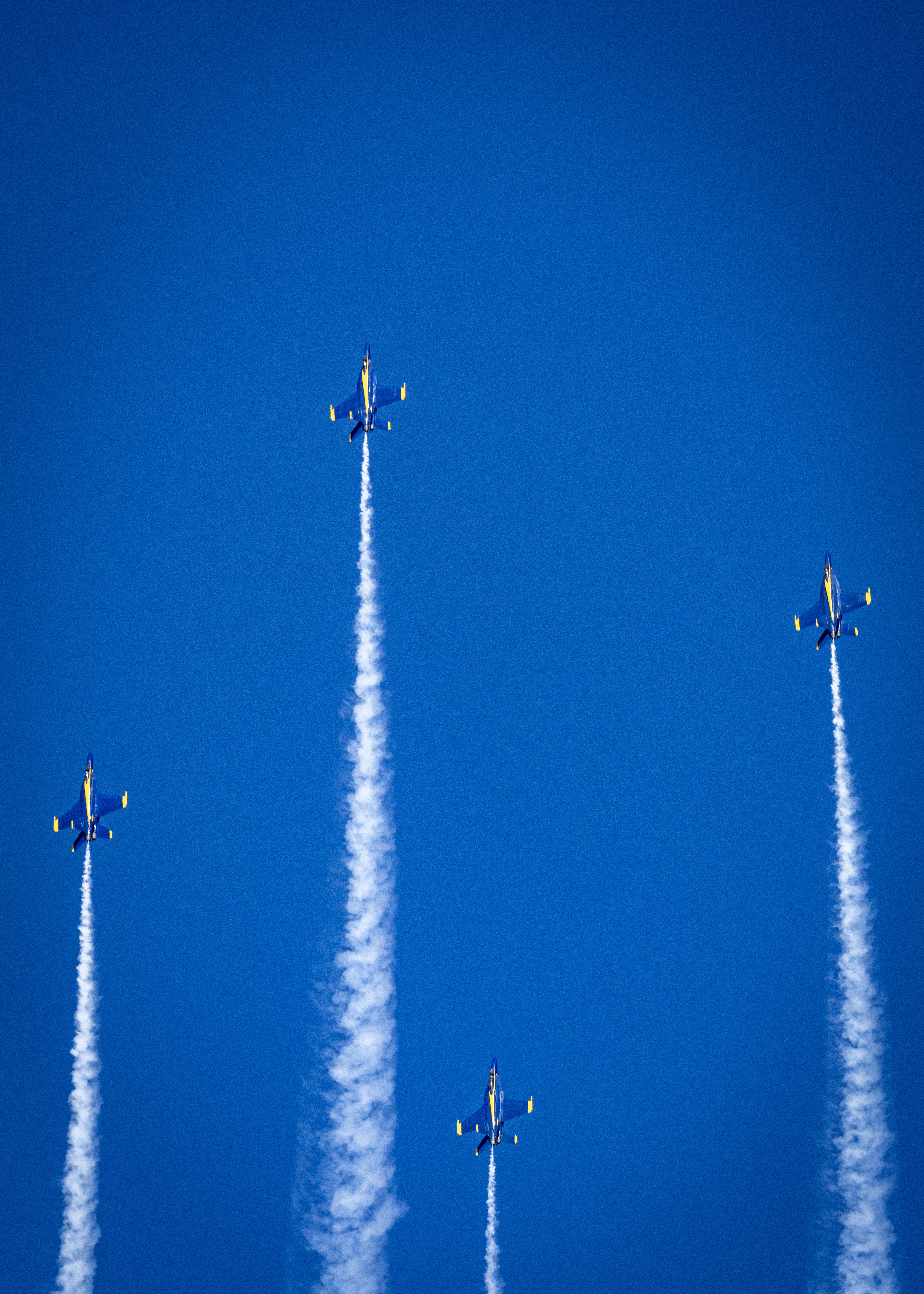 Blue Angels jets appear along separate vertical smoke trails.