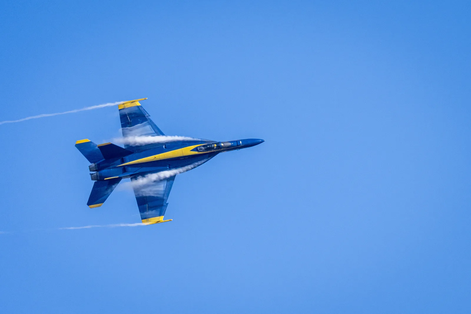 Blue Angels jet No. 5 passes overhead, showing its underside markings.