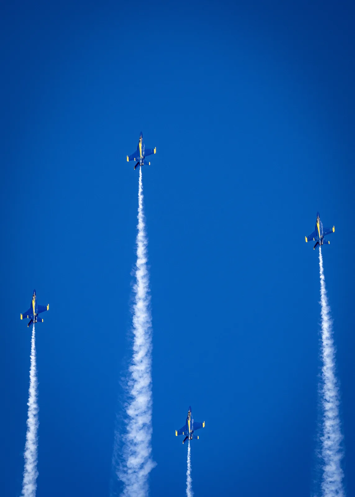 Blue Angels jets appear along separate vertical smoke trails.